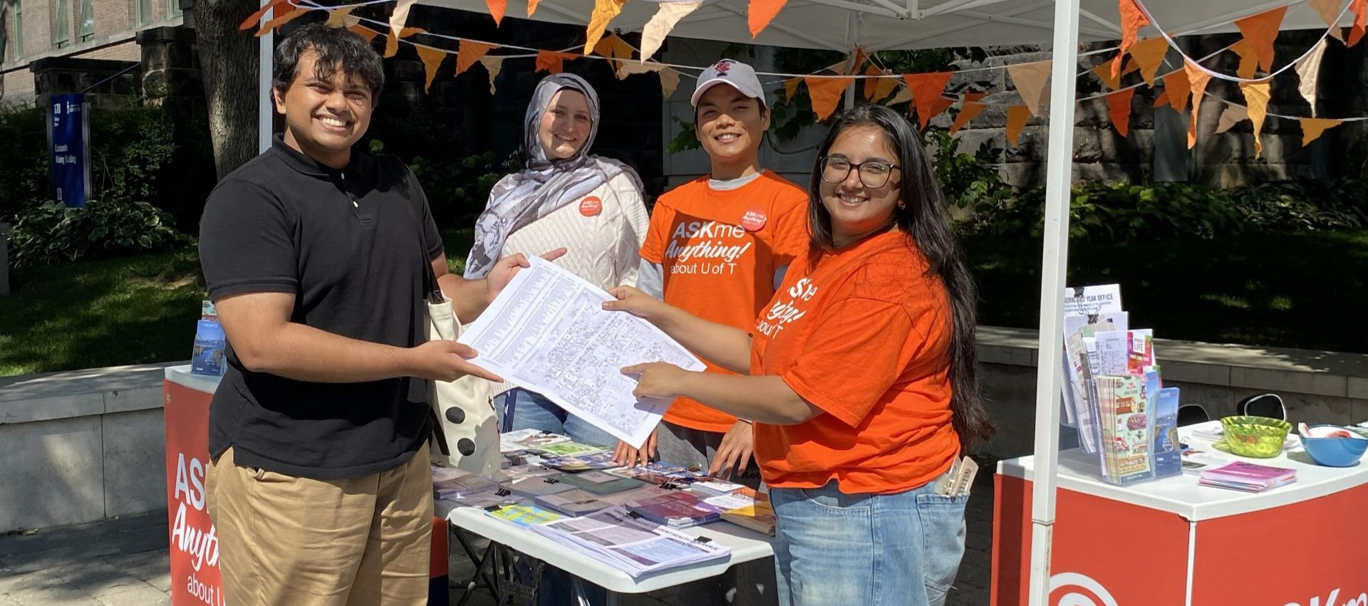 AskMe ambassadors helping a student at a booth.