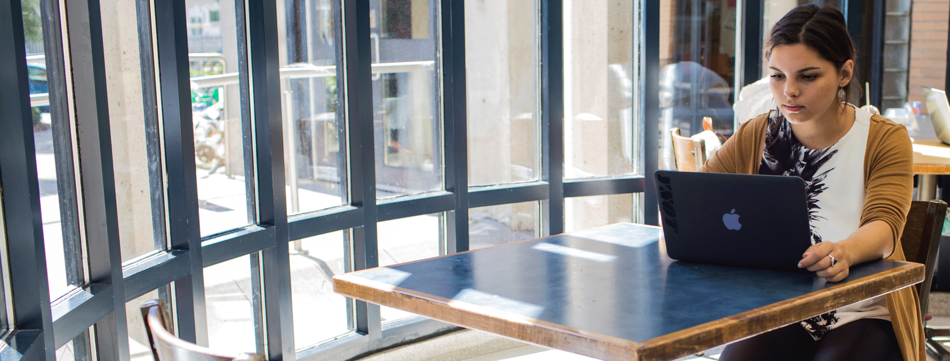 Young woman sitting at a table in Multi-Faith lobby