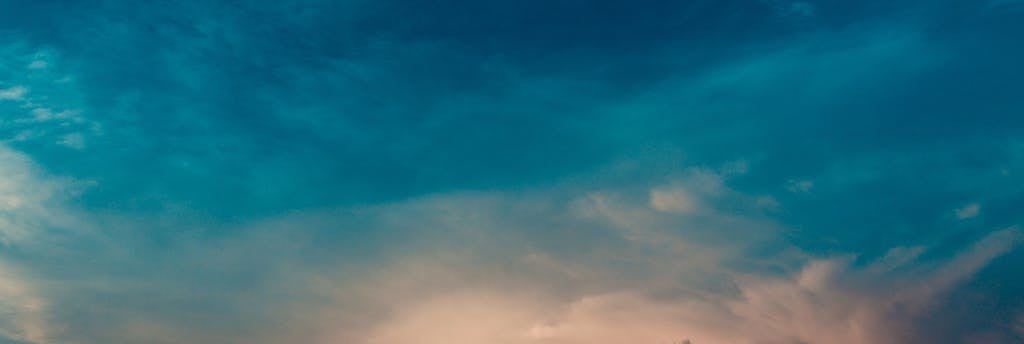 Serene sky with soft clouds illuminated during sunset, perfect for peaceful backgrounds.